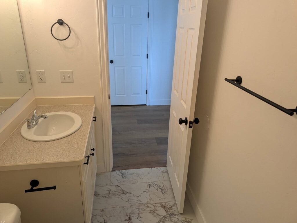 Finished bathroom with updated flooring, vanity hardware and fixtures by The Nelsons Crew